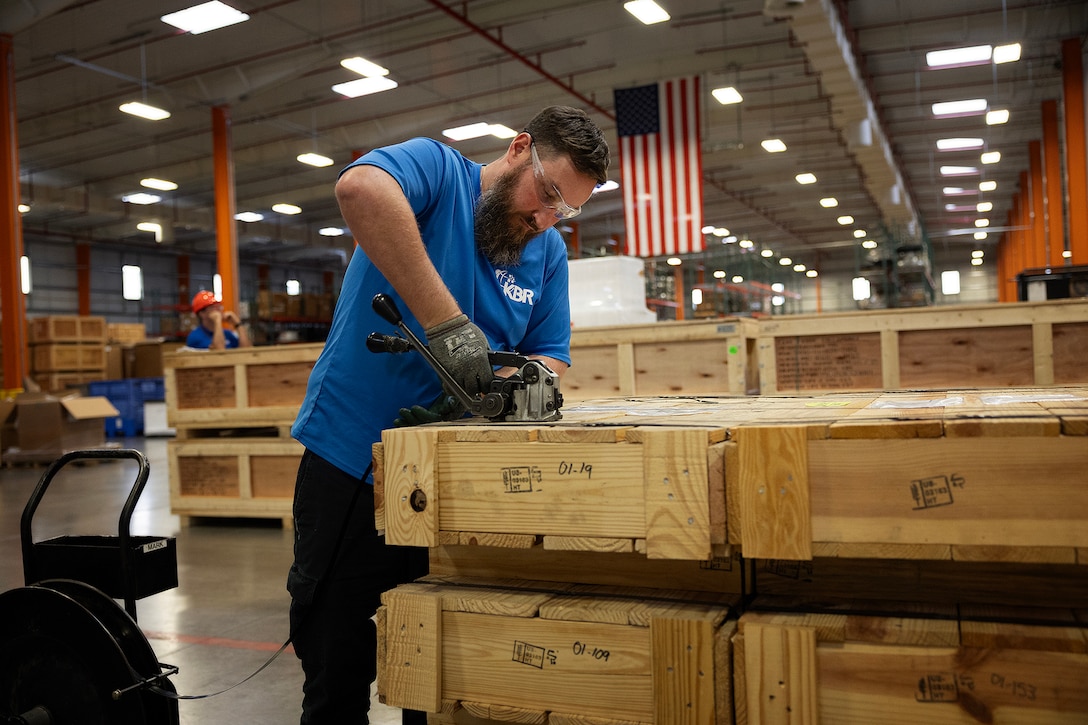 Contractor Derek Visyak, a shipping coordinator with Blount Island Command, bands armored vehicle windows from prepositioning stocks Oct. 10, 2025, at Marine Corps Support Facility Blount Island, Florida. The panels were packaged for transport in response to an urgent request from Marines operating in the U.S. Southern Command area of responsibility. Blount Island Command approved the request immediately, ensuring deployed forces received critical force-protection equipment without delay. The effort demonstrated the reach of the Jacksonville-based sustainment network and strengthened joint logistics readiness across the region. (U.S. Marine Corps photo by Dustin Senger)