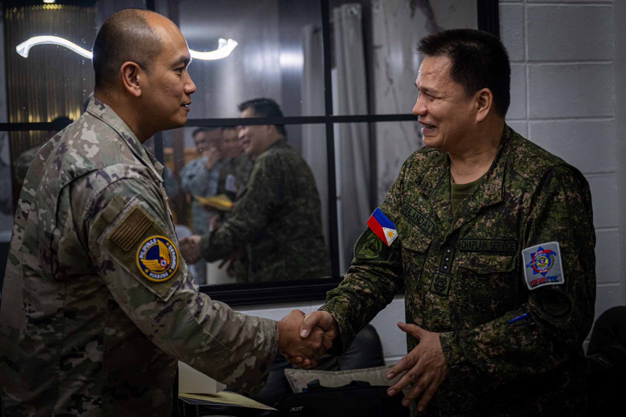 U.S. Air Force Maj. Karlo Rivera, 21st Air Expeditionary Wing logistics planning officer, left, and Philippine Air Force Col. Denis Bulanday, Headquarters PAF chief air chaplain, right, shake hands during a chaplain fellowship exchange at Clark Air Base, Philippines, April 22, 2026. The PAF chaplains and 21st AEW facilitated discussions on the importance of spiritual fitness and strengthened the relationship between the two organizations. (U.S. Air Force photo by Airman 1st Class Adrien Tran)