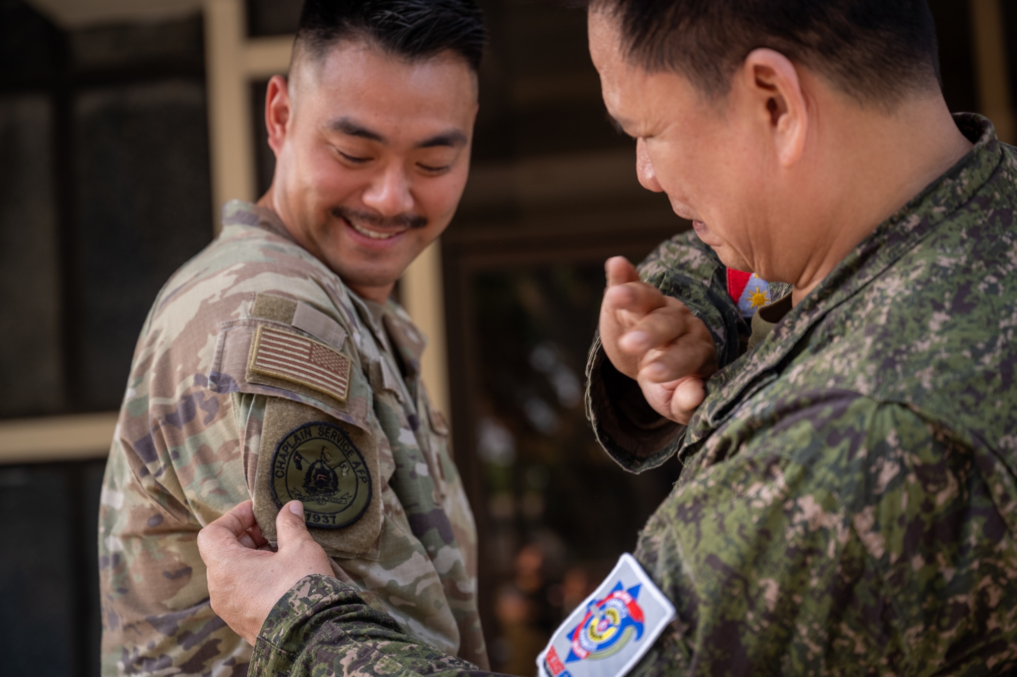 Philippine Air Force Col. Denis Bulanday, Headquarters Philippine Air Force chief air chaplain, right, places a patch on U.S. Air Force Capt. Joseph Jun, 21st Air Expeditionary Wing chaplain, left, during a chaplain fellowship exchange at Clark Air Base, Philippines, April 22, 2026. Patch swapping is a long-standing military tradition that symbolizes the exchange of camaraderie, mutual respect and shared mission commitment between partnered forces. (U.S. Air Force photo by Airman 1st Class Adrien Tran)