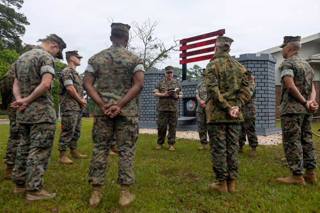 U.S. Marines and Sailors with 2nd Marine Logistics Group listen to a prayer led by U.S. Navy Lt. Shawn Downey, the chaplain of 8th Engineer Support Battalion, Combat Logistics Regiment 27, 2nd Marine Logistics Group, at Marine Corps Base Camp Lejeune, North Carolina, May 7, 2026. 8th ESB hosted a public prayer in honor of National Day of Prayer to increase unit cohesion and spiritual readiness. (U.S. Marine Corps photo by Lance Cpl. Isabella Ramos)