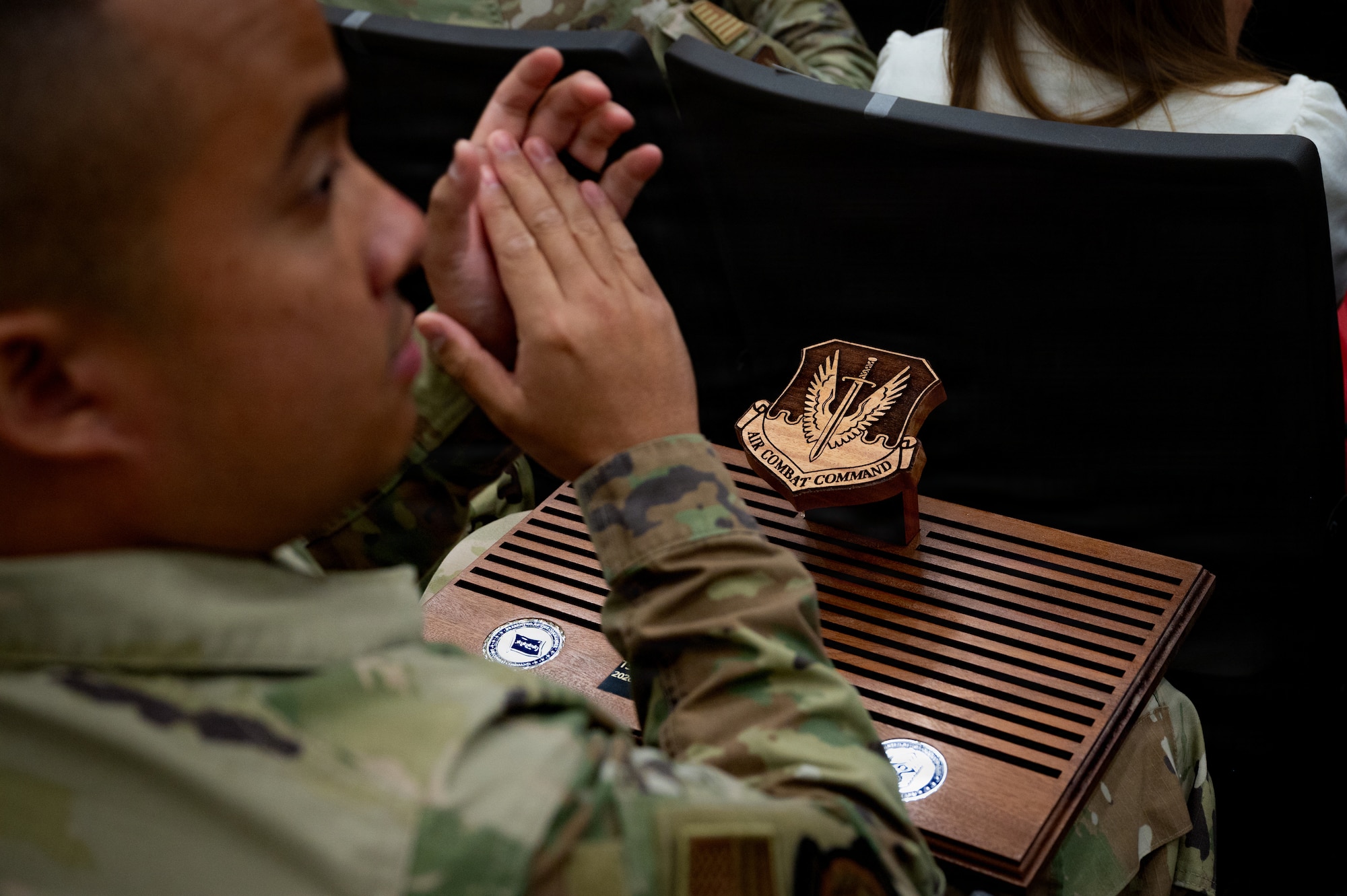 An award sits static while attendees clap during the 2026 Air Combat Command’s Outstanding Airmen of the Year Award ceremony at Joint Base Langley-Eustis, Virginia, May 6, 2026. The award belongs to Tech. Sgt Marc Rouisse G. Quijano, 355th Security Forces Squadron, ACC Noncommissioned Officer of the year award 2026 recipient. Award winners will go on to compete at the Air Force level. (U.S. Air Force photo by Staff Sgt. Michael Bowman)