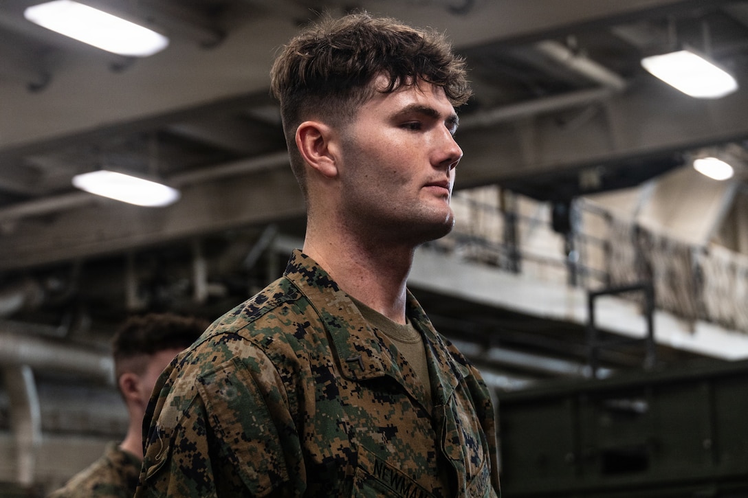 U.S. Marine Corps Pfc. Joseph Newman, a rifleman with Lima Company, Battalion Landing Team 3/5, 11th Marine Expeditionary Unit, waits to be promoted in the well deck of San Antonio-class amphibious transport dock ship USS Portland (LPD 27), in the Pacific Ocean, Dec. 7, 2025. The 11th MEU is currently underway aboard the Boxer Amphibious Ready Group in the U.S. 3rd Fleet area of operations conducting integrated training that enhances lethality and warfighting readiness. (U.S. Marine Corps photo by Lance Cpl. Luke Rodriguez)