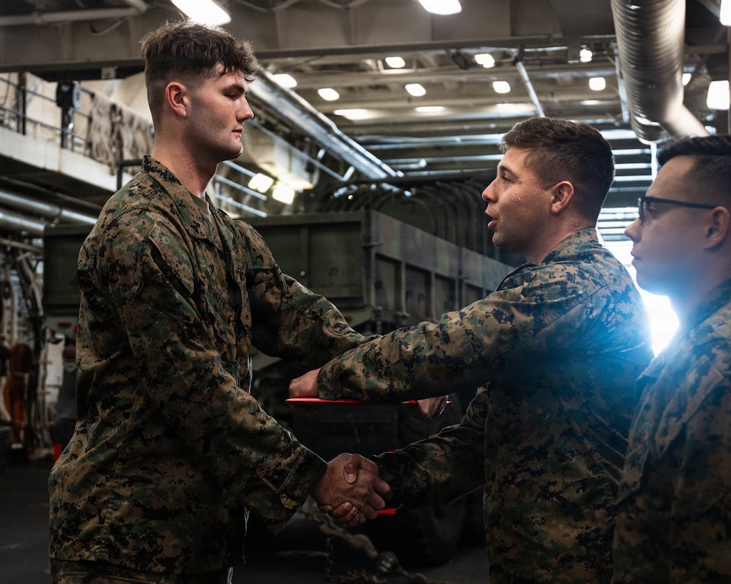 U.S. Marine Corps Lance Cpl. Joseph Newman, a rifleman with Lima Company, Battalion Landing Team 3/5, 11th Marine Expeditionary Unit, receives a promotion warrant in the well deck of San Antonio-class amphibious transport dock ship USS Portland (LPD 27), in the Pacific Ocean, Dec. 7, 2025. The 11th MEU is currently underway aboard the Boxer Amphibious Ready Group in the U.S. 3rd Fleet area of operations conducting integrated training that enhances lethality and warfighting readiness. (U.S. Marine Corps photo by Lance Cpl. Luke Rodriguez)