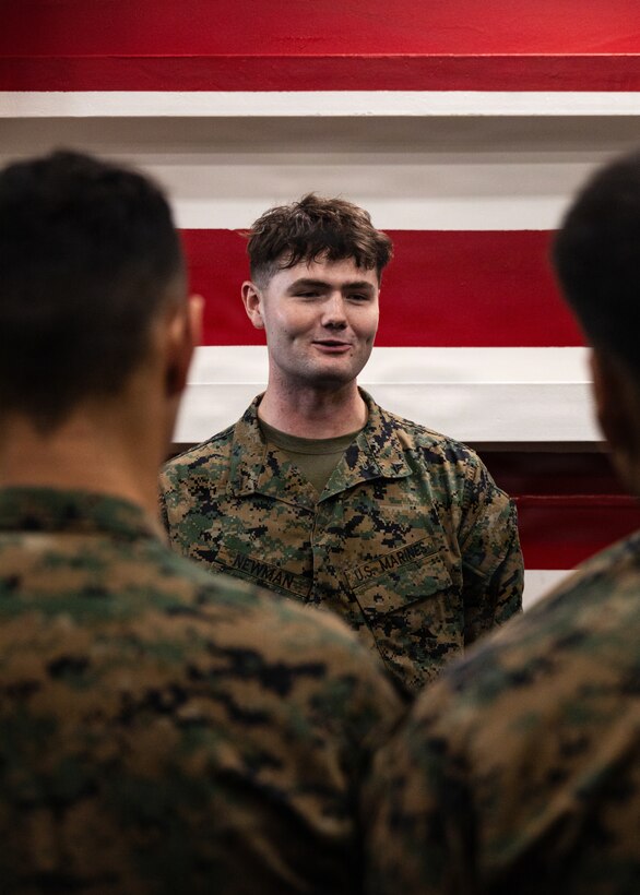 U.S. Marine Corps Lance Cpl. Joseph Newman, a rifleman with Lima Company, Battalion Landing Team 3/5, 11th Marine Expeditionary Unit, speaks to the audience after being promoted to the rank of lance corporal in the well deck of San Antonio-class amphibious transport dock ship USS Portland (LPD 27), in the Pacific Ocean, Dec. 7, 2025. The 11th MEU is currently underway aboard the Boxer Amphibious Ready Group in the U.S. 3rd Fleet area of operations conducting integrated training that enhances lethality and warfighting readiness. (U.S. Marine Corps photo by Lance Cpl. Luke Rodriguez)