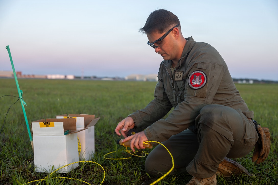 U.S. Marine Corps Sgt. Kyle Smith, an explosive ordnance disposal technician with Headquarters and Headquarters Squadron, Marine Corps Air Station Cherry Point, prepares an explosive charge for a live detonation exercise at MCAS Cherry Point, North Carolina, May 4, 2026. This exercise demonstrates the skill and precision of EOD technicians in a controlled environment as they execute pyrotechnic effects in support of the 2026 MCAS Cherry Point Air Show and the Wall of Fire display. (U.S. Marine Corps photo by Lance Cpl. Dillon Anderson)