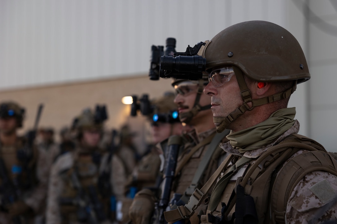 U.S. Marine Corps Staff Sgt. Brian Stewart, an identity and attribution activities examiner with the 11th Marine Expeditionary Unit, I Marine Expeditionary Force, receives a brief prior to a raid during Realistic Urban Training at Marine Corps Air Station Yuma, Arizona, Nov. 10, 2025. RUT is a land-based training exercise that enables the 11th MEU to conduct expeditionary operations as a cohesive Marine Air-Ground Task Force in preparation for amphibious operations alongside the U.S. Navy. (U.S. Marine Corps photo by Cpl. Oliver Nisbet)