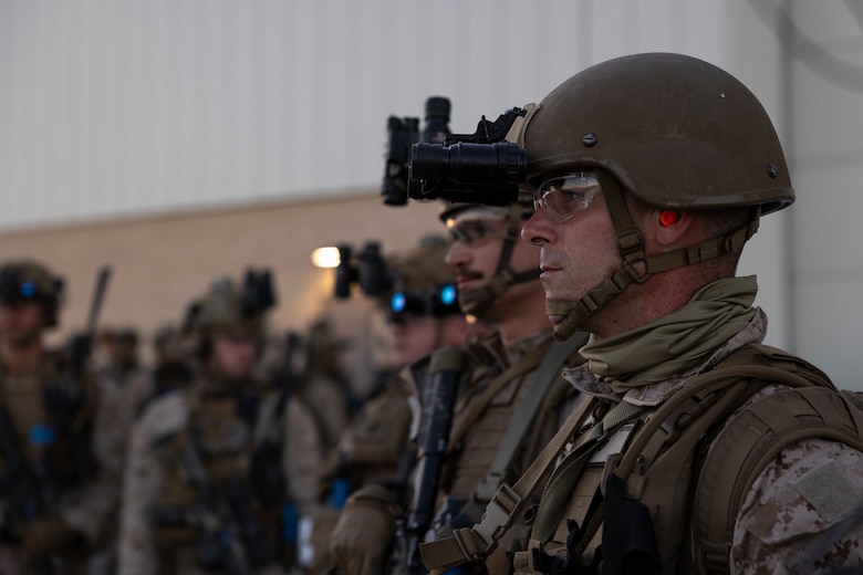 U.S. Marine Corps Staff Sgt. Brian Stewart, an identity and attribution activities examiner with the 11th Marine Expeditionary Unit, I Marine Expeditionary Force, receives a brief prior to a raid during Realistic Urban Training at Marine Corps Air Station Yuma, Arizona, Nov. 10, 2025. RUT is a land-based training exercise that enables the 11th MEU to conduct expeditionary operations as a cohesive Marine Air-Ground Task Force in preparation for amphibious operations alongside the U.S. Navy. (U.S. Marine Corps photo by Cpl. Oliver Nisbet)