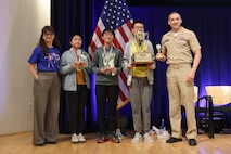 Winners of the “Countdown Round” pose with their trophies alongside Carderock leadership during the 15th annual Carderock Math Contest (CMC) at Naval Surface Warfare Center, Carderock Division