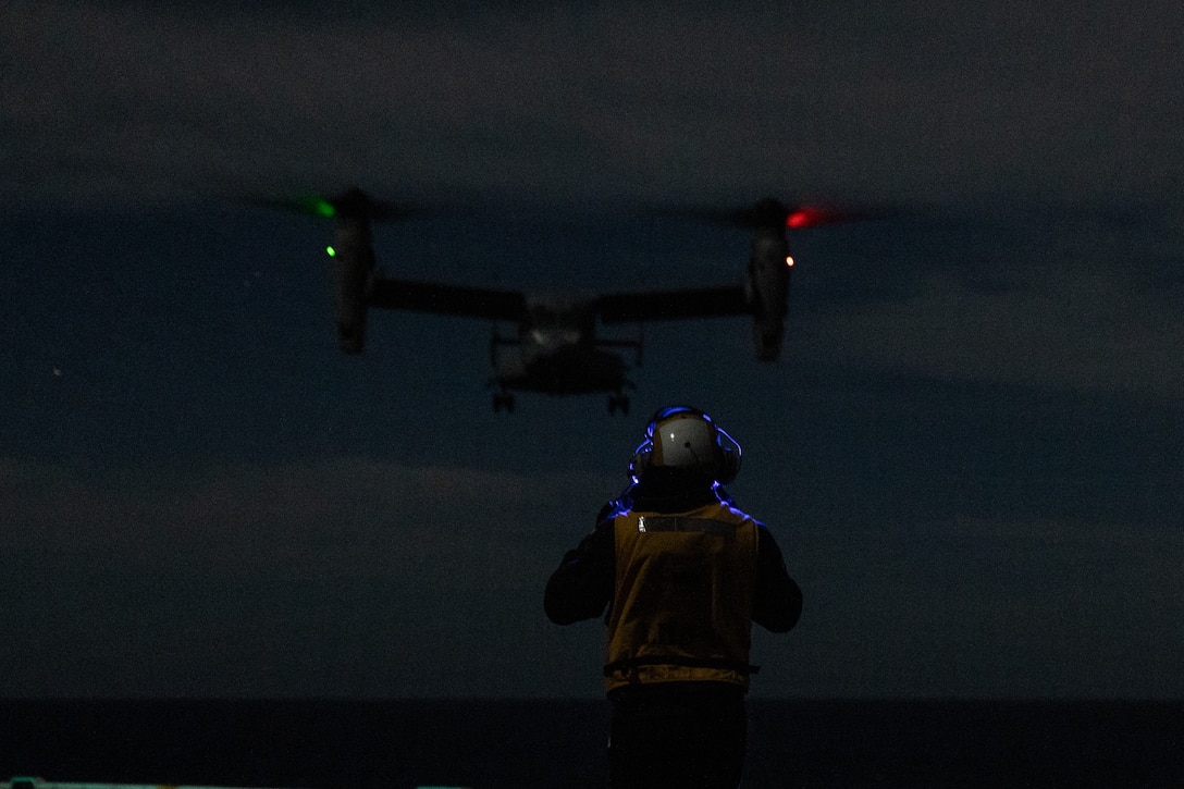 A U.S. Sailor assigned to Wasp-class amphibious assault ship USS Boxer (LHD 4), directs the landing of an MV-22B Osprey with Marine Medium Tiltrotor Squadron (VMM) 163 (Reinforced), 11th Marine Expeditionary Unit, in the Pacific Ocean, Dec. 3, 2025. The 11th MEU is currently underway aboard the Boxer Amphibious Ready Group in the U.S. 3rd Fleet area of operations conducting integrated training that enhances lethality and warfighting readiness. (U.S. Marine Corps photo by Cpl. Oliver Nisbet)