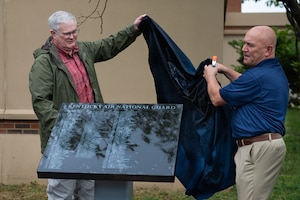 Retired Brig. Gen. David Mounkes, left, former assistant adjutant general for Air in the Kentucky National Guard, and retired Master Sgt. Chris Tells, former senior enlisted leader for the 123rd Contingency Response Group, unveil a plaque containing the names of 53 2025 retirees during a ceremony at the Kentucky Air National Guard Base in Louisville, Ky., April 18, 2026. The plaque honors Airmen who completed at least 20 years of military service at the Kentucky Air Guard last year. (U.S. Air National Guard photo by Airman 1st Class Angelee Barnett)