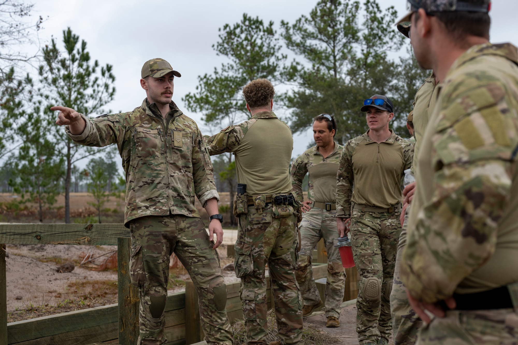 A Royal Danish Air Force military member talks with U.S. Air Force personnel during a field training exercise