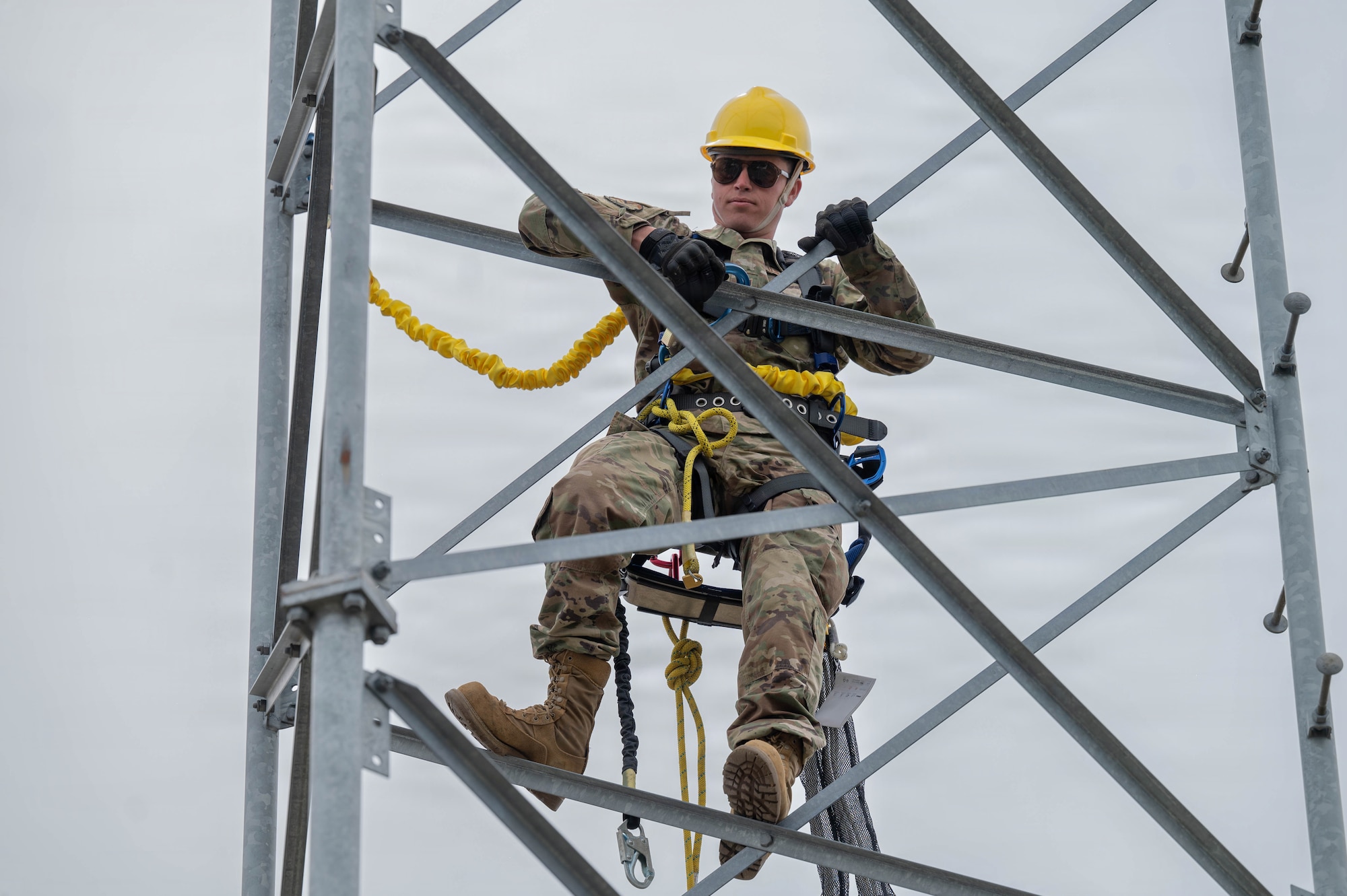 Airmen climb a tower.