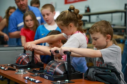 Children operate ship control equipment during a test site tour at Naval Surface Warfare Center, Philadelphia Division’s (NSWCPD) annual Take Our Children to Work Day on April 23, 2026. The hands-on demonstration introduced children to the types of control systems and shipboard technologies NSWCPD engineers use to support Navy readiness and Sailors. (U.S. Navy photo by Jay Butterbaugh, CTR)