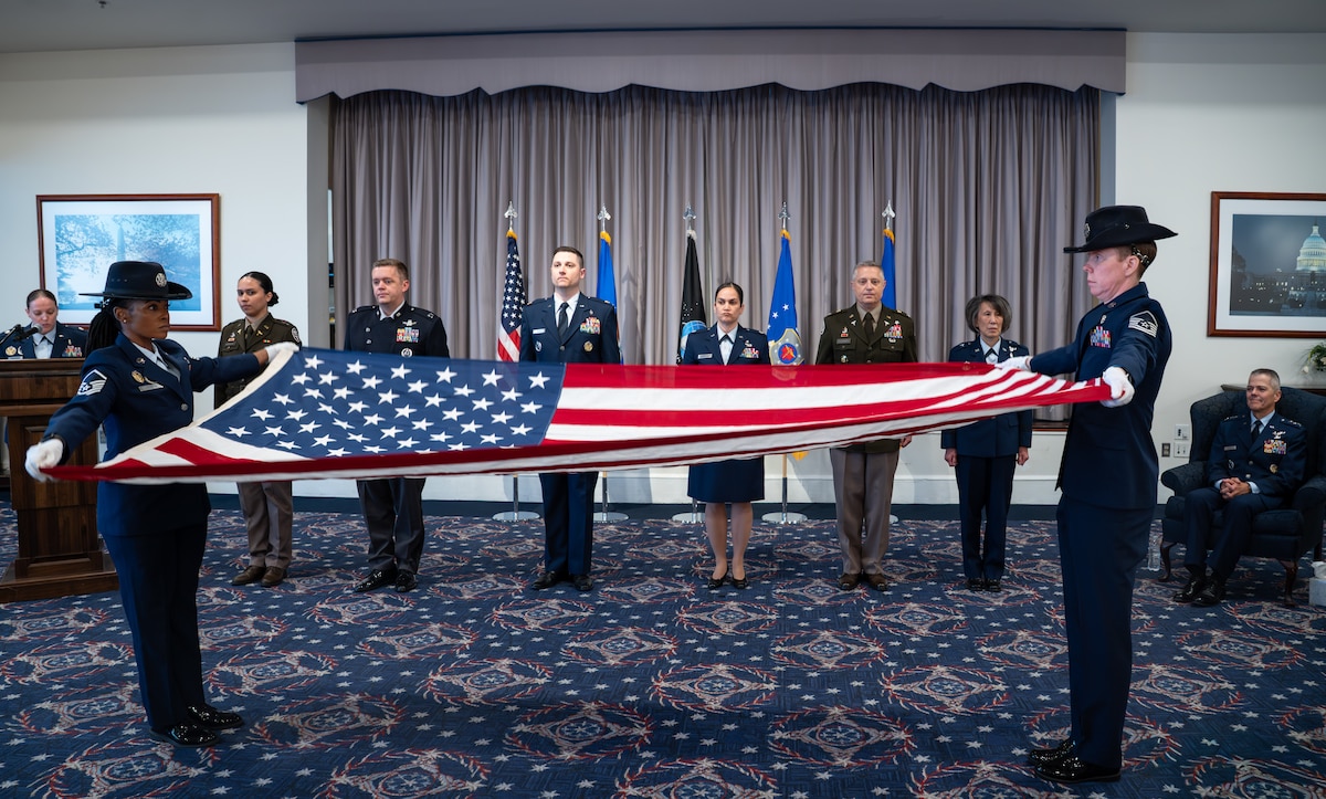 Image of Airmen displaying the U.S. flag.