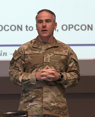 Chief Master Sgt. Raun Howell makes remarks while standing.