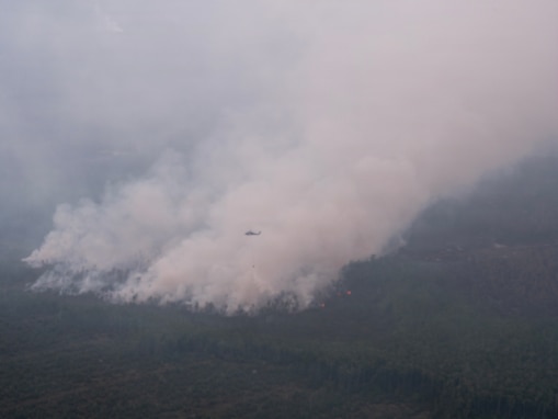 A UH-60 Black Hawk helicopter of the 78th Aviation Troop Command, Georgia National Guard, conducts fire suppression operations over wildfires in southern Georgia.