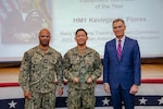 260504-N-KC192-1041 PORTSMOUTH, Va. (May 4, 2026) Hospital Corpsman 1st Class Kevinjay Flores, center, assigned to the Medical Education and Training Campus, is presented the Shore-Based Biomedical Equipment Technician of the Year Award by Dr. Michael McGinnis, Bureau of Medicine and Surgery (BUMED) executive director, during the 2026 Medical Logistics Symposium held on board Naval Medical Center Portsmouth, May 4, 2026. Flores was recognized for training the next generation of technicians, strengthening the technical readiness and reliability of equipment supporting deployed medical forces. The Navy Medicine Logistics Symposium aims to maintain a common operating picture and update the Medical Logistics community regarding the fiscal year 2026 Navy Medicine Campaign Order and the Navy MEDLOG goal to build a logistics system that delivers ready operational units to support the Naval Strategy. (U.S. Navy photo by Mass Communication Specialist Second Class Levi Decker)