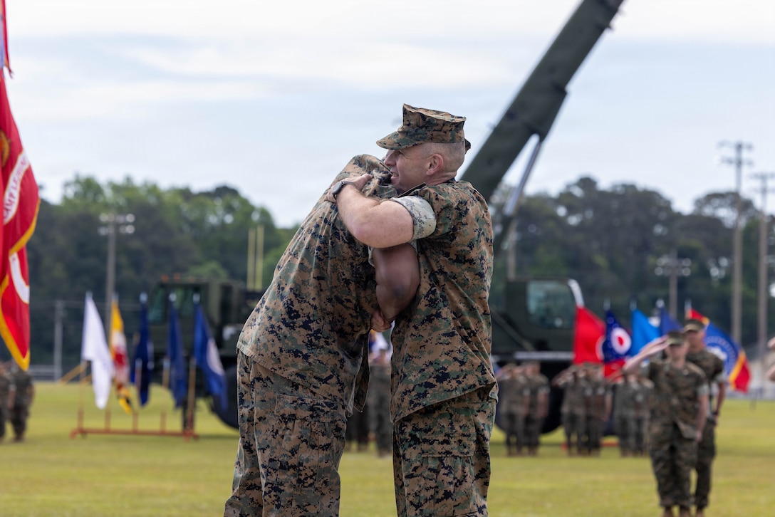 U.S. Marine Corps Col. Gregory B. Pace, the incoming commander, Marine Corps Installations East-Marine Corps Base Camp Lejeune, and U.S. Marine Corps Brig. Gen. Ralph J. Rizzo, Jr., the outgoing commanding general, MCIEAST-MCB Camp Lejeune, embrace during a relinquishment of command ceremony at W.P.T. Hill Field on MCB Camp Lejeune, North Carolina, May 8, 2026. During the ceremony, Rizzo relinquished command of MCIEAST to Pace. Pace is a native of Tuskegee, Alabama, and Rizzo is a native of Charlestown, Massachusetts. (U.S. Marine Corps photo by Lance Cpl. Erica S. Padgett)