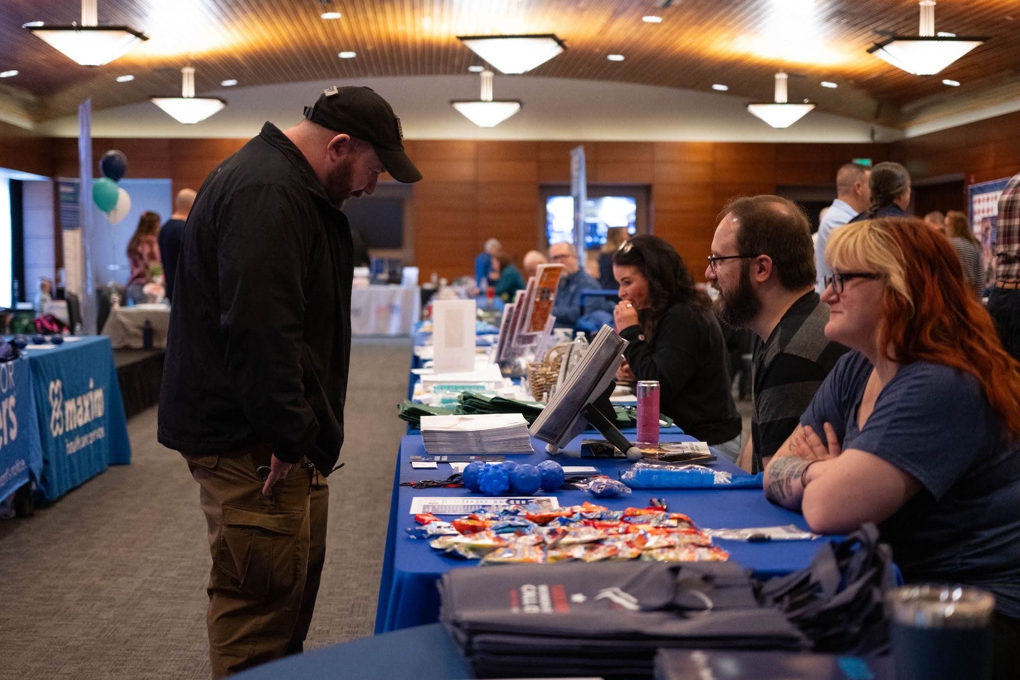 A veteran speaks with a vendor during the Retiree Appreciation Day event on Joint Base Elmendorf-Richardson, Alaska, May 1, 2026. Multiple booths were set up to provide veterans with resources, such as civilian employment advisors and recreational organizers, to help them after they’ve retired from service. (U.S. Air Force photo by Airman 1st Class Owen Davies)