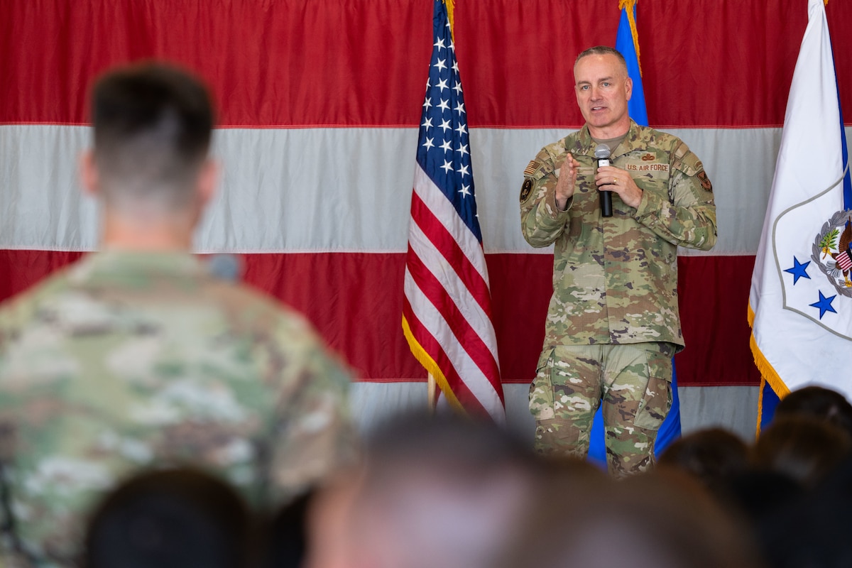 Air Force Chief Master Sergeant of the Air Force David Wolfe points toward a standing Airman while speaking, with other seated Airmen visible in the audience.