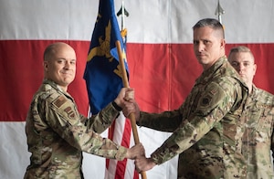 Col. Aaron Gray, 55th Wing commander, passes the guidon to incoming 55th Maintenance Group commander, Col. Eric Burke, during the 55th MXG change of command ceremony on Offutt Air Force Base, Neb., May 1, 2026. A change of command ceremony is a formal, time-honored tradition that symbolizes the official transfer or responsibility from one commanding officer to another. (U.S. Air Force photo by Daniel Martinez)