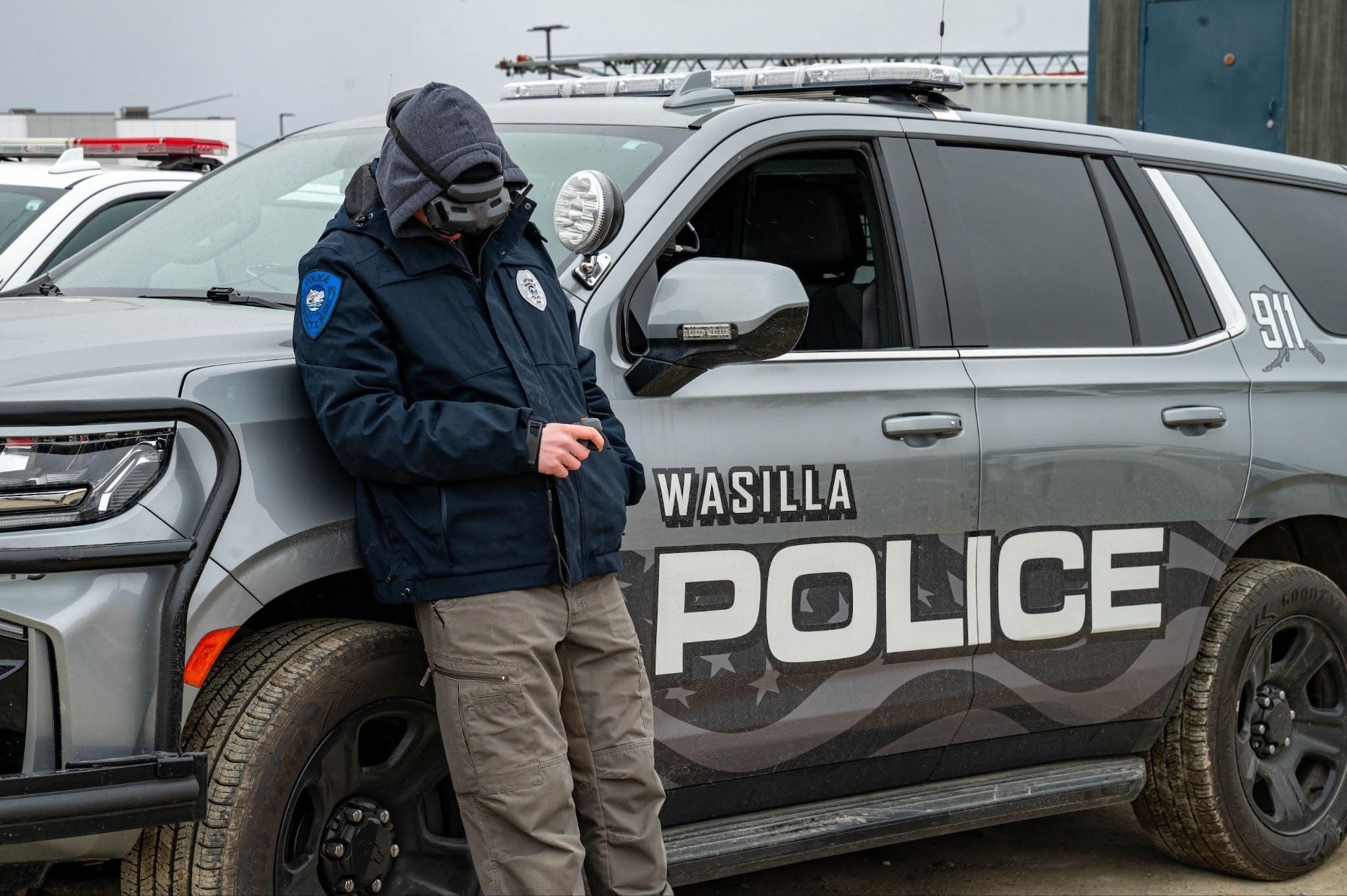An officer from the Wasilla Police department controls a drone during a search and rescue exercise in Wasilla, Alaska, April 30, 2026. During this exercise, operators with Joint Base Elmendorf-Richardson Explosive Ordnance Disposal and other agencies were required to navigate through buildings and perform scanning routes to find unexploded ordnance and human objectives. (U.S. Air Force photo by Airman 1st Class Owen Davies)