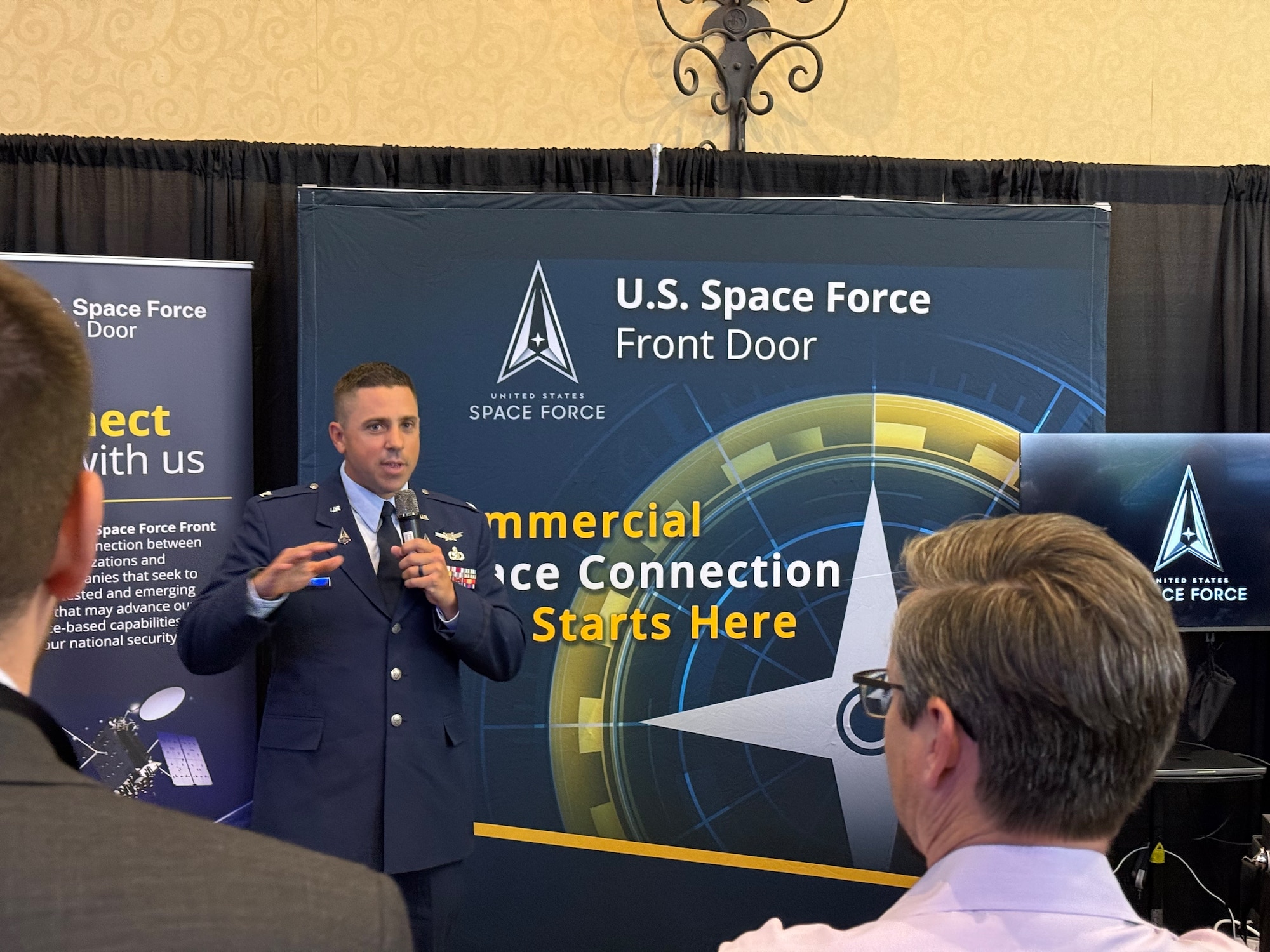 Col. Timothy Trimailo, Director, Space Systems Command (SSC) Commercial Space Office (COMSO), speaks with assembled attendees on April 15, 2026 during the 41st Space Symposium in Colorado Springs, Colorado. Col Trimailo was a featured speaker at the United States Space Force (USSF) Front Door’s exhibit booth to discuss the various pathways in which industry can engage with the USSF acquisition teams through COMSO. (USSF photo by Paul Hewitt)