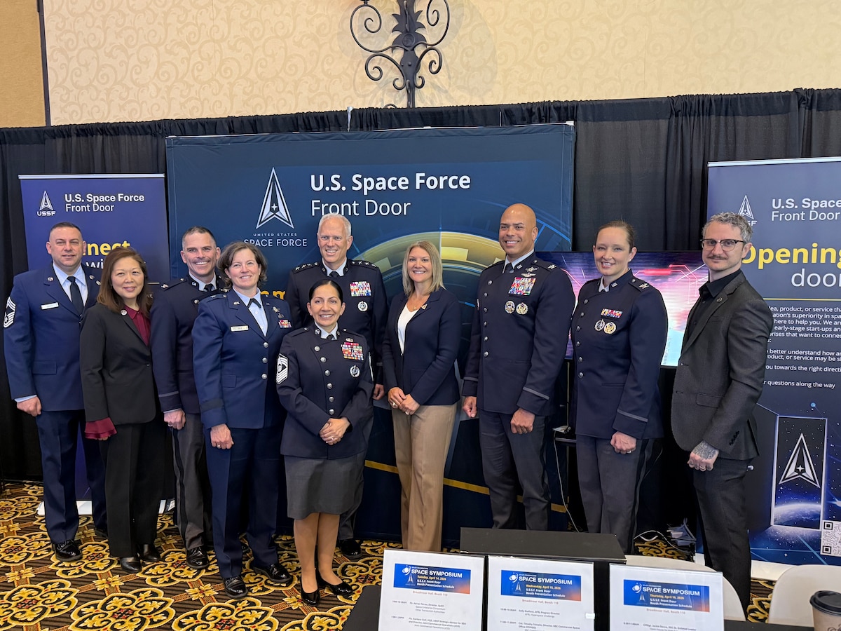 The Space Systems Command leadership team gathers at the United States Space Force (USSF) Front Door’s exhibition booth on April 15, 2026 during the 41st Space Symposium in Colorado Springs, Colorado. The USSF Front Door served as the primary liaison to industry partners and convention attendees during this year’s annual Space Symposium, engaging with existing and potential vendors and hosting a series of expert speakers across the 3-day event.   (USSF photo by Paul Hewitt)