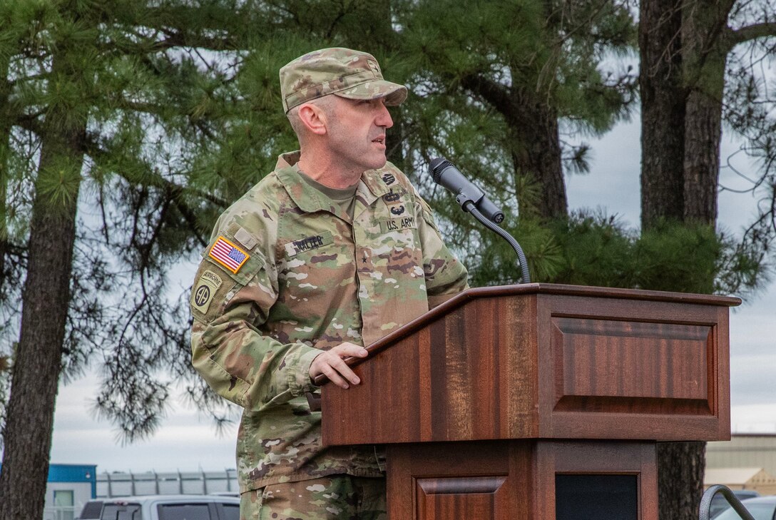 man in military uniform standing at a podium with a microphone