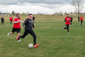 Nuke FC player kicks a soccer ball at a goal during a soccer game against a Great Falls team.