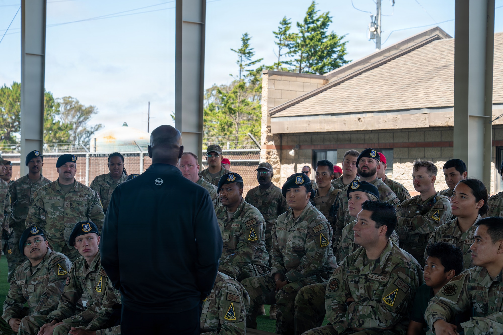 Kaleth O. Wright speaks to a group of military members sitting and standing around him.