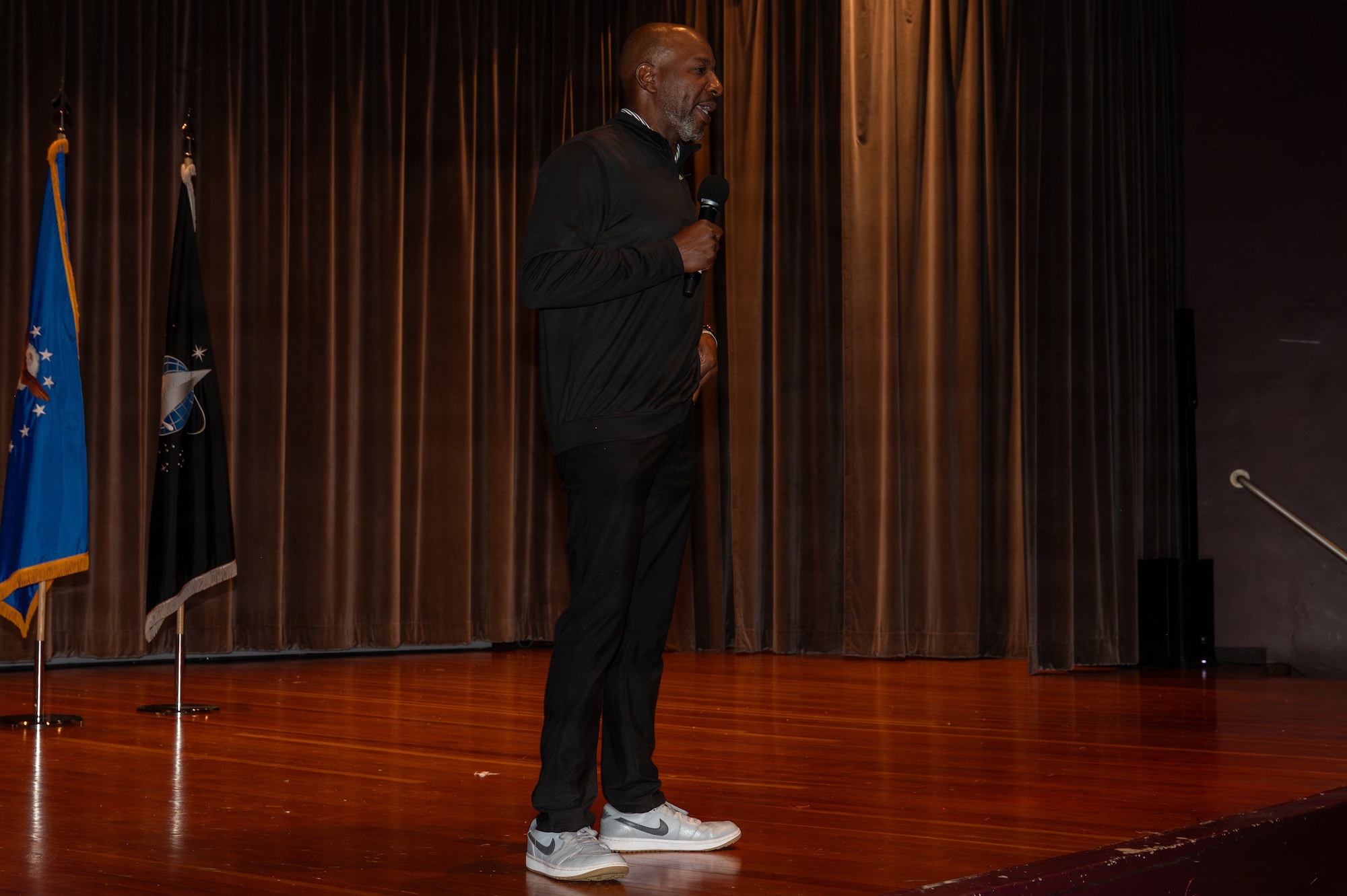 Kaleth O. Wright stands on a stage and speaks.
