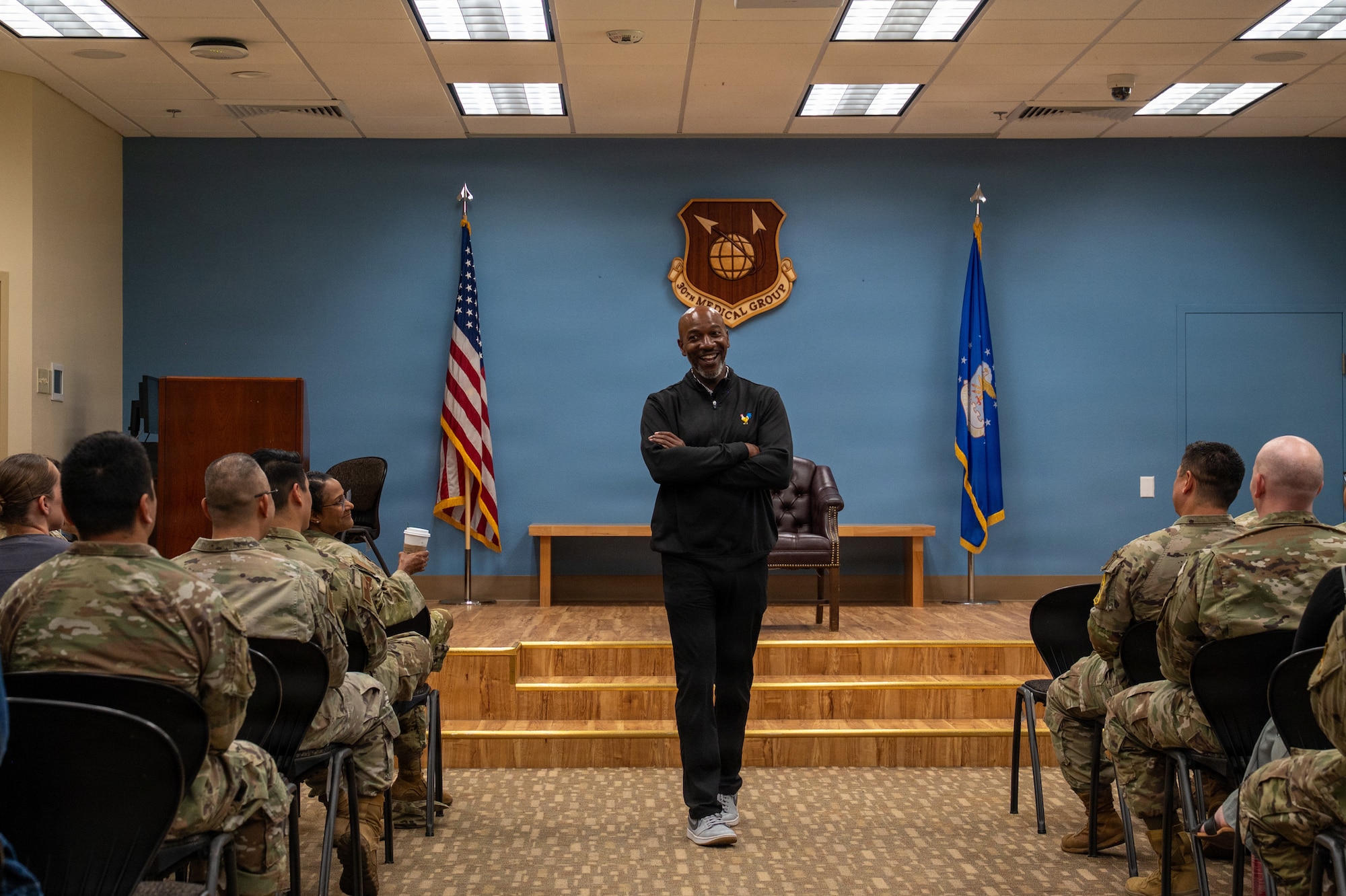 Kaleth O. Wright smiles at the servicemembers sitting in rows of chairs.