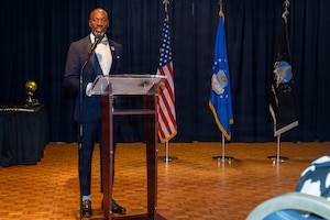 Kaleth O. Wright stands behind a podium and speaks.