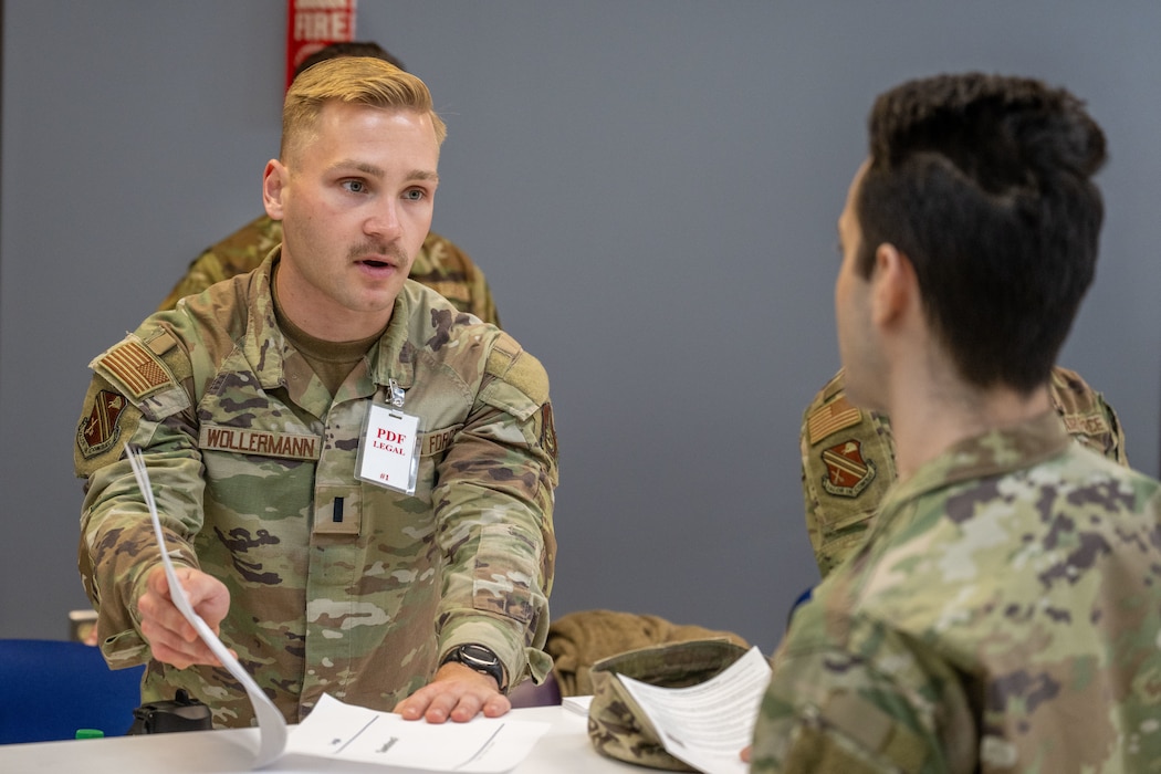 1st Lt. Zach Wollermann, 354th Fighter Wing Judge Advocate Office legal assistance chief, processes an Airman for a simulated deployment process