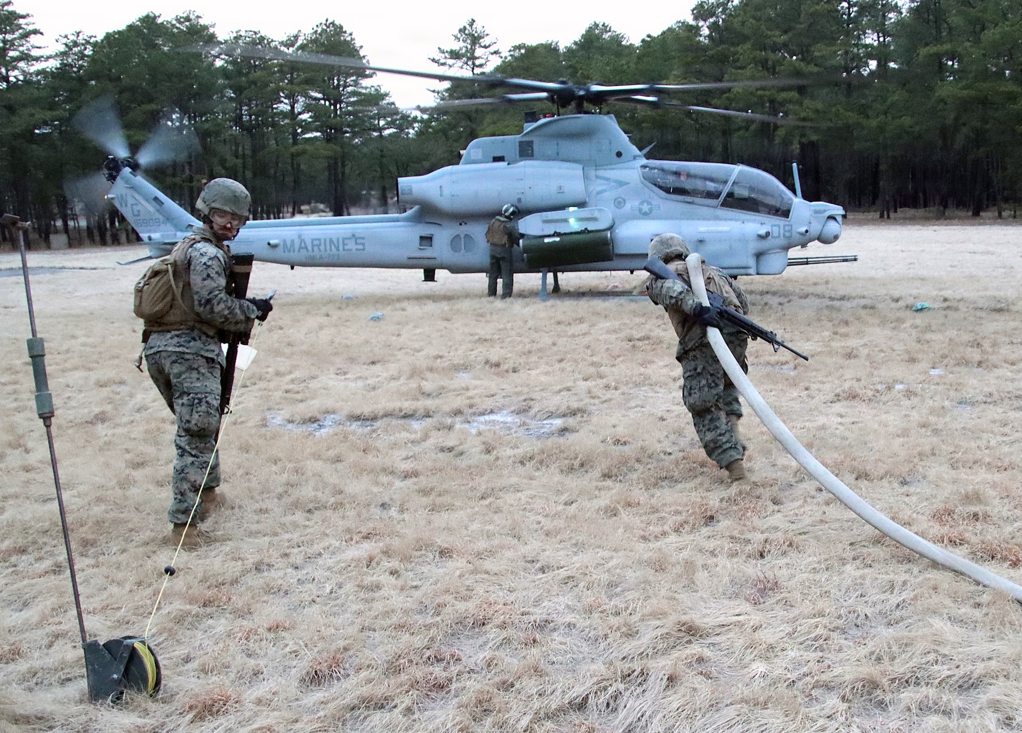 U.S. Marine Corps Reserve Marines assigned to the Marine Wing Support Squadron 472 approach an AH-1 Cobra helicopter to initiate the fueling process at their forward arming and refueling point during a combined arms live-fire exercise at Joint Base McGuire-Dix-Lakehurst, N.J., March 22, 2026. The FARP training familiarized Marines with the procedures for refueling aircraft in field environments. The CALFEX, led by 2nd Battalion, 25th Marines Regiment, integrated forces from Marine Forces Reserve units based in New Jersey and operating out of JB MDL to conduct aviation and ground operations throughout the exercise, linking logistics, fires and maneuver elements in a continuous training scenario. (U.S. Army photo by Steven Roussel)