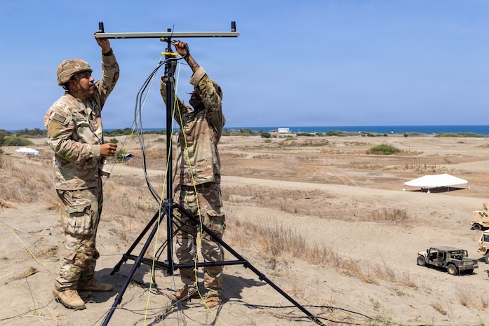 U.S. Army Pfc. Saul Aidaria, left, and Sgt. Jonathan Hillman, both signal support system specialist assigned to 25th Infantry Division Artillery, establishes signal connectivity during Exercise Balikatan 2026 at La Paz Sand Dunes, Laoag City, Philippines, May 1, 2026.