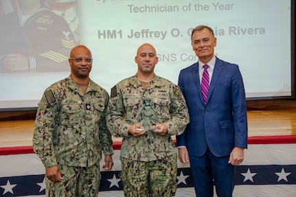 260504-N-KC192-1037 PORTSMOUTH, Va. (May 4, 2026) Hospital Corpsman 1st Class Jeffrey Garcia Rivera, assigned to Mercy-class hospital ship USNS Comfort (T-AH 20), the Operational Biomedical Equipment Technician of the Year Award by Dr. Michael McGinnis, Bureau of Medicine and Surgery (BUMED) executive director, during the 2026 Medical Logistics Symposium held on board Naval Medical Center Portsmouth, May 4, 2026. Garcia Rivera was recognized for ensuring critical medical equipment remained mission-ready in austere environments, directly supporting life-saving care and operational continuity in expeditionary settings. The Navy Medicine Logistics Symposium aims to maintain a common operating picture and update the Medical Logistics community regarding the fiscal year 2026 Navy Medicine Campaign Order and the Navy MEDLOG goal to build a logistics system that delivers ready operational units to support the Naval Strategy. (U.S. Navy photo by Mass Communication Specialist Second Class Levi Decker)