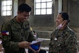 Philippine Nurse Corps 2nd Lt. Ronaldo Lucas, left, a nurse assigned to 2nd Technical Administrative Services Brigade and U.S. Navy Hospital Corpsman 1st Class Sheena Beltran, a corpsman assigned to 1st Medical Battalion, 1st Marine Logistics Group, I Marine Expeditionary Force, converse during a cooperative health engagement as part of Exercise Balikatan 2026 in San Vicente, Philippines, April 21, 2026.