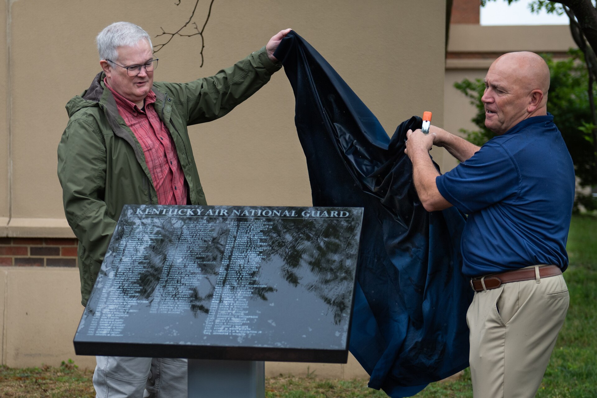 Retired Brig. Gen. David Mounkes, left, former assistant adjutant general for Air in the Kentucky National Guard, and retired Master Sgt. Chris Tells, former senior enlisted leader for the 123rd Contingency Response Group, unveil a plaque containing the names of 53 2025 retirees during a ceremony at the Kentucky Air National Guard Base in Louisville, Ky., April 18, 2026. The plaque honors Airmen who completed at least 20 years of military service at the Kentucky Air Guard last year. (U.S. Air National Guard photo by Airman 1st Class Angelee Barnett)