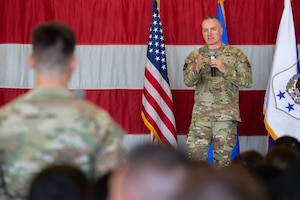 Air Force Chief Master Sergeant of the Air Force David Wolfe points toward a standing Airman while speaking, with other seated Airmen visible in the audience.