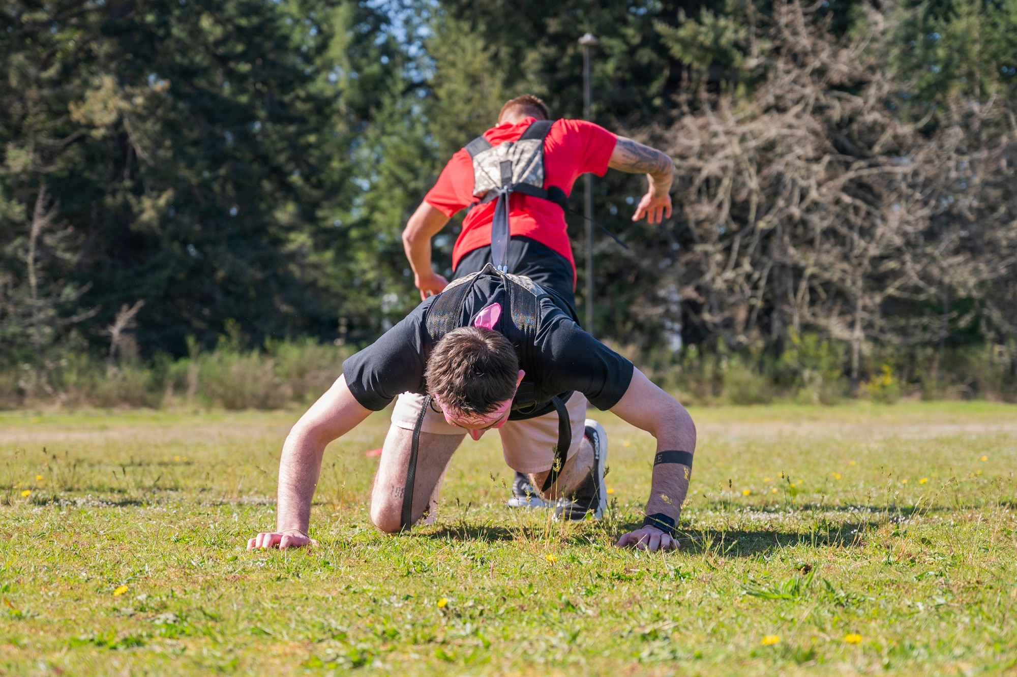 U.S. Air Force Senior Airman Michael Houser, 62d Medical Squadron Air Force Alcohol and Drug Abuse Prevention and Treatment technician, black shirt, and Senior Airman Matthew Ramos, 7th Airlift Squadron loadmaster, compete in the “Tug-of-Strength” event during the Julius A. Kolb Airman Leadership School Commandant’s Crucible at Joint Base Lewis-McChord, Washington, April 7, 2026.
