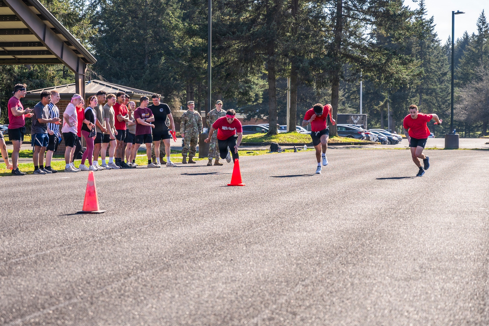 U.S. Air Force Senior Airman David Sala, 62d Maintenance Group wing analyst, left runner, Senior Airman Thaddeus Lindsey, 627th Force Support Squadron food service shift leader, center runner, and Senior Airman Matthew Ramos, 7th Airlift Squadron loadmaster, compete in a sprint race during the Julius A. Kolb Airman Leadership School Commandant’s Crucible at Joint Base Lewis-McChord, Washington, April 7, 2026.