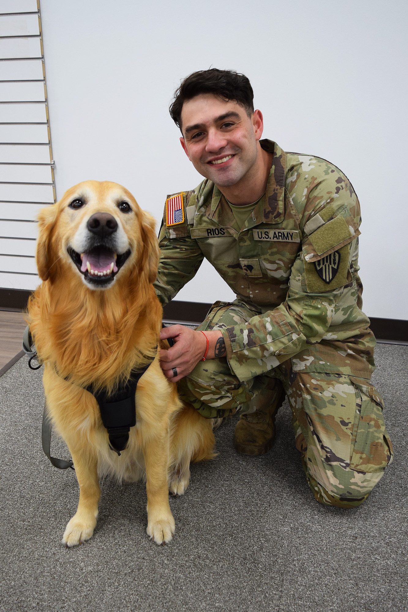 U.S. Army Spc. Nicholas Rios, a motor vehicle operator assigned to Headquarters and Headquarters Company, 369th Special Troops Battalion, 369th Sustainment Brigade, New York Army National Guard, is welcomed by therapy dog Ranger, at the new USO center at Joint Base McGuire-Dix-Lakehurst, N.J., April, 23, 2026. The 6,600-square-foot center features Wi-fi, computers, gaming systems, televisions, pool tables and enhanced lounge areas with refreshments, all at no cost to active duty, Reserve and National Guard service members, retirees and their dependents with valid identification. (U.S. Air Force photo by Kris Patterson)