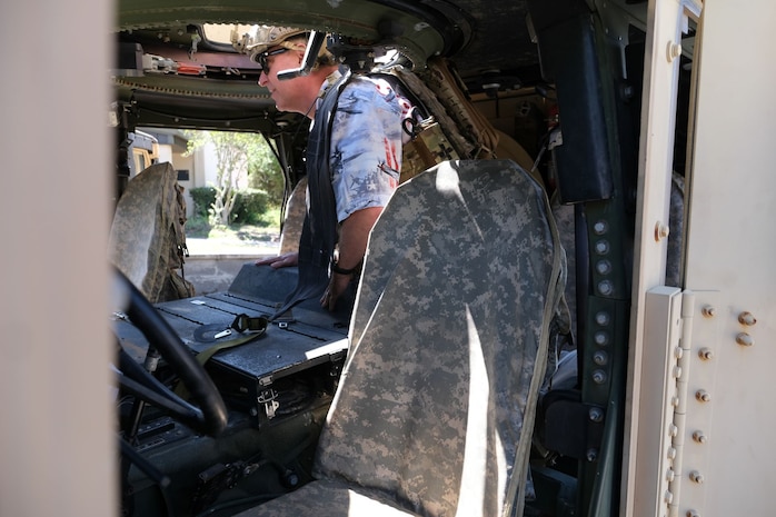 photo of civic leader cllimbing into a Humvee