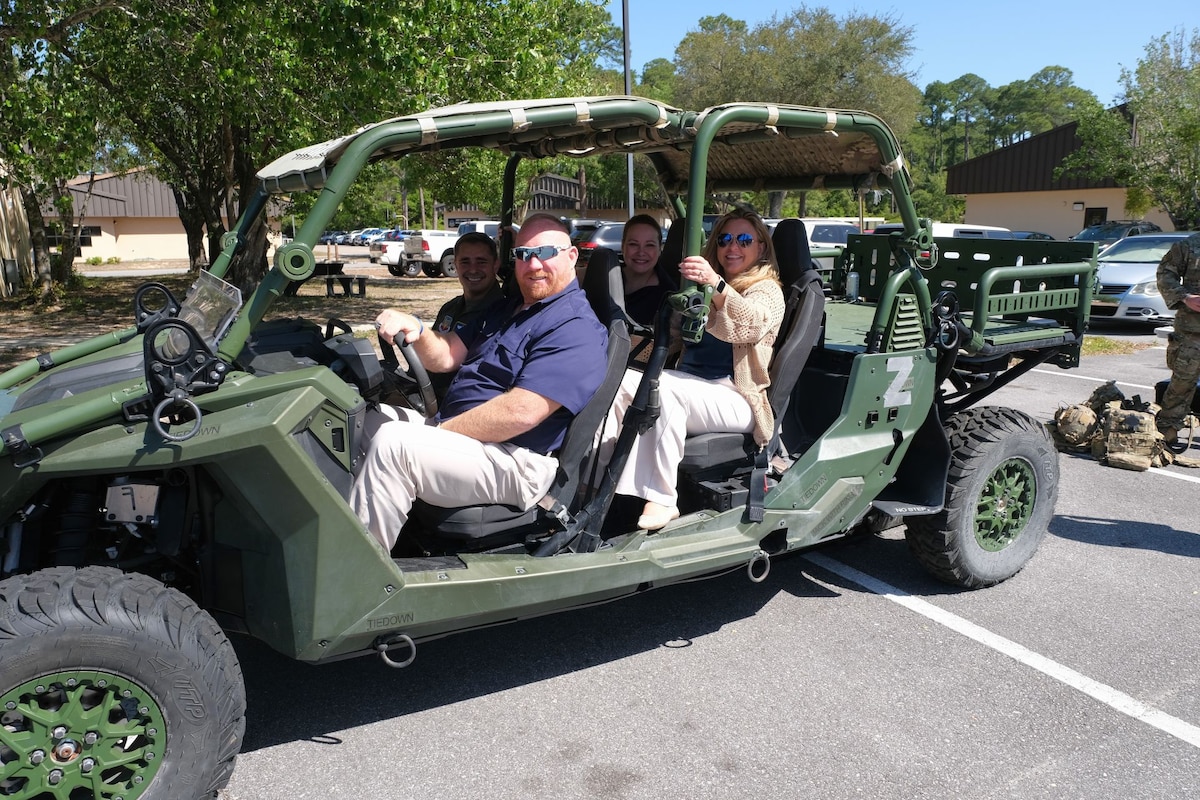photo of civic leaders in a light tactical all-terrain vehicle