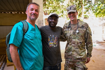 Austrian Army Col. Christian Schützenhöfer, a dentist, and U.S. Army Sgt. 1st Class Tim Farrow, a flight medic with the Vermont Army National Guard, pose with a Senegalese patient following a dental extraction during a multinational medical readiness exercise, or MEDREX, in Ziguinchor, Senegal, May 6, 2026.