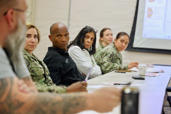 Hospital leaders assigned to Navy Medicine Readiness and Training Command Twentynine Palms listen as Richard Osborne (left), emergency management specialist, discusses his role during a potential pandemic response during an influenza pandemic tabletop exercise April 9, 2026. The discussion-based exercise evaluated the command’s emergency response procedures, Hospital Incident Command System activation, and operational readiness during a simulated H7N3 influenza pandemic scenario. (U.S. Navy photo by Christopher Jones, NMRTC / NH Twentynine Palms public affairs officer)