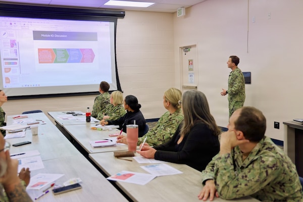 Lt. j.g. David Naiman (back-right), environmental health officer and Preventive Medicine Department head assigned to Navy Medicine Readiness and Training Command Twentynine Palms, leads an influenza pandemic tabletop exercise at the command April 9, 2026. The discussion-based exercise with a wide variety of hospital leaders evaluated the command’s emergency response procedures, Hospital Incident Command System activation, and operational readiness during a simulated H7N3 influenza pandemic scenario. (U.S. Navy photo by Christopher Jones, NMRTC / NH Twentynine Palms public affairs officer)