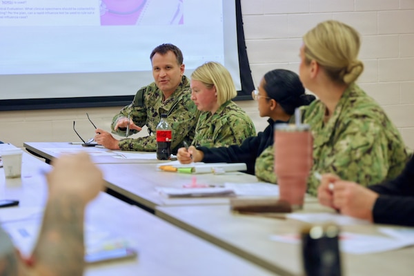 Capt. Mark Miller (back left), chief nursing officer assigned to Navy Medicine Readiness and Training Command Twentynine Palms, discusses the impact a hypothetical pandemic would have on the command with hospital leadership during an influenza pandemic tabletop exercise April 9, 2026. The discussion-based exercise evaluated the command’s emergency response procedures, Hospital Incident Command System activation, and operational readiness during a simulated H7N3 influenza pandemic scenario. (U.S. Navy photo by Christopher Jones, NMRTC / NH Twentynine Palms public affairs officer)